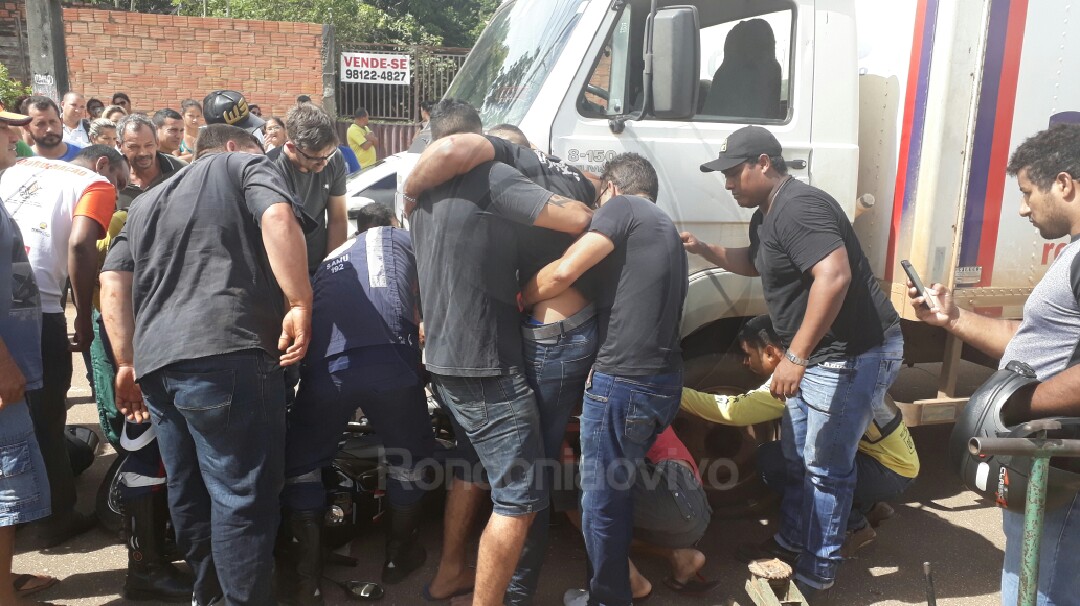 SOFRIMENTO: Motociclista grita de dor ao ficar com perna presa em caminhão