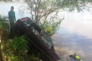 Criança dá partida em carro e cai dentro de rio