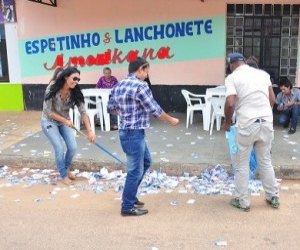 Candidatos limpam frente de escola inundada por “santinhos”