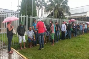 Trabalhadores esperam na chuva por seguro-desemprego